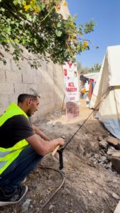 متطوع من إحسان للإغاثة الإنسانية يساعد في تركيب خيمة في غزة