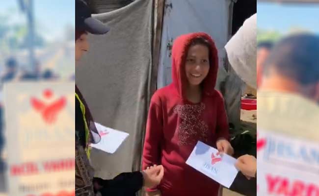 توزع مساعدات نقدية في أحد المخيمات جنوب قطاع غزة